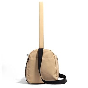Détail du sac de voyage en nylon beige avec bandoulière et cordon de serrage latéral