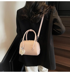 Detail of pink leather pillow bag with pearl heart pendant and fashion text print
