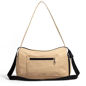 Détail du sac de voyage beige avec poche zippée et bandoulière réglable noire