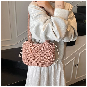 Detailed shot of a pink hand-woven bucket bag with drawstring closure and braided handle