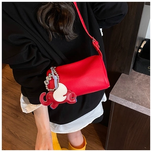 Detail of red cylinder bag with lychee pattern and elephant leather charm decoration