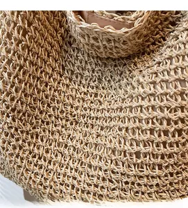 Close-up of natural woven straw texture and durable stitching on a large beach tote bag