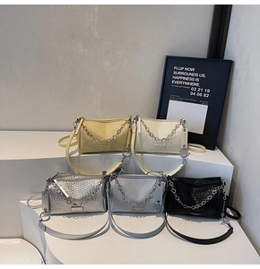 Close-up of woven shoulder bags in five colors with metal chain and leather straps