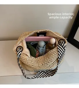 Macro shot of large straw tote bag showing spacious interior with tablet and umbrella