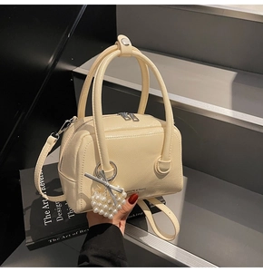 Detail of cream Boston bag with lychee texture leather and heart pearl charm