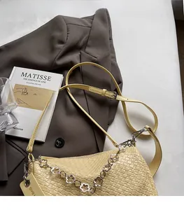 Detail of yellow woven shoulder bag with floral silver chain and adjustable strap