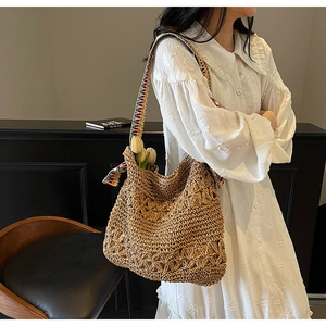 Detail of handmade straw tote with colorful bohemian strap and hollow crochet pattern