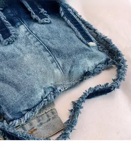 Vue détaillée du tissu denim délavé avec bords effilochés et textures rétro vintage