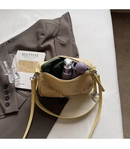 Interior capacity detail of yellow woven crossbody bag holding phone and umbrella