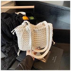 Detailed macro view of white hand-woven cotton rope texture and drawstring closure on bag
