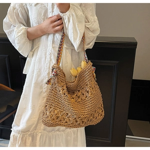 Detail of handmade straw tote bag featuring hollow floral texture and ethnic woven strap