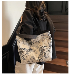 Large canvas tote bag with black ink bamboo print worn by model over a black blazer