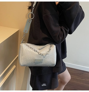 Detail view of woven leather crossbody bag with metal chain and GOOD MOMENT logo