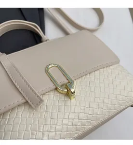 Detail einer beige geflochtenen Handtasche mit poliertem goldenem ovalem Metallverschluss