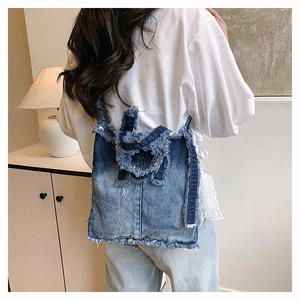 Vue arrière d'un mannequin portant un sac cabas en jean dégradé avec bords effilochés