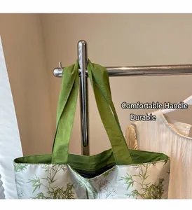 Close-up of durable green fabric handle and bamboo pattern on silver tote bag