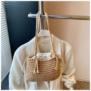 Detail of hand-woven straw bucket bag with natural texture and white drawstring lining