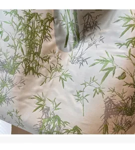 Detail of soft silk-like fabric with green bamboo print and smooth metallic texture
