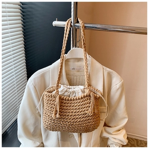 Detail of hand-woven bucket bag featuring a drawstring liner and long tassels decor