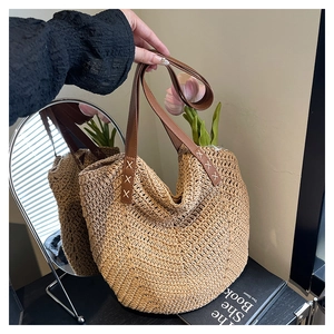 Detailaufnahme der Strohtasche mit braunem Ledergriff und weißer Ziernaht für den Sommer