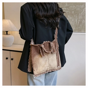 Détail d'un sac en denim vintage avec dégradé de marron et bords effilochés