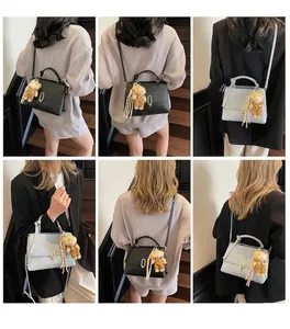 Detail der gewebten Handtasche mit süßem Bärenanhänger und goldener Metallschnalle