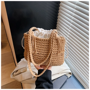 Detail of hand-woven bucket bag featuring a white drawstring inner pouch and braided handle