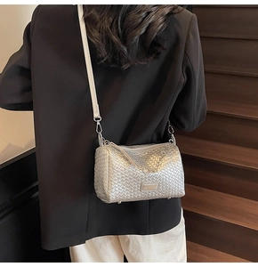 Detail of silver woven crossbody bag with metallic texture and sleek shoulder strap