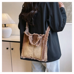 Détail des bords effilochés et du dégradé de couleurs sur un sac en denim vintage