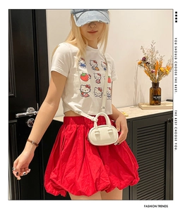 Detail shot of a fashion white mini bowling crossbody bag paired with a red puffy skirt