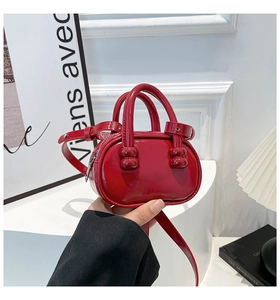 Close-up of red patent leather bowling bag with glossy finish and silver hardware details
