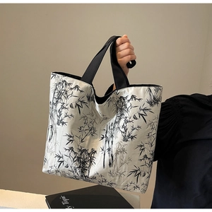Detail view of large canvas tote bag with black and white ink bamboo pattern and woven strap