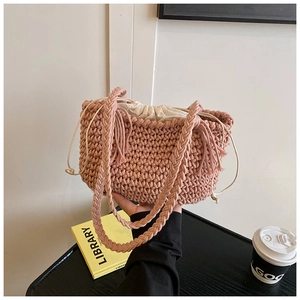 Detail of pink hand-woven knit bucket bag featuring a thick strap and drawstring liner