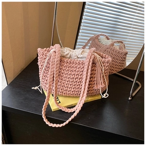Detail of pink hand-woven bucket bag showing textured crochet pattern and drawstring lining