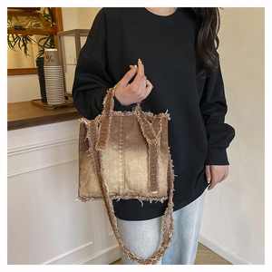 Gros plan détaillé d'un sac cabas en denim vintage avec franges et dégradé de marron