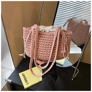 Detail of hand-woven bucket bag in dusty pink with drawstring lining and braided tassel strap