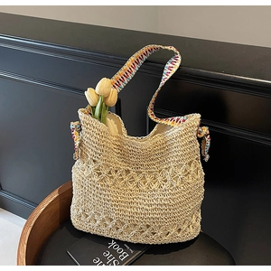 Detailed macro of handmade straw bag featuring diamond hollow weave and colorful strap