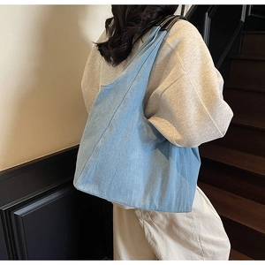 Vista posteriore di una borsa tote in denim azzurro con grande capacità e trama lavata