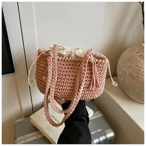 Detail of hand-woven purple crochet bucket bag with cream drawstring liner and tassel strap