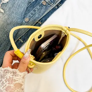 Interior view of yellow leather bucket bag showing capacity for smartphone and lipstick