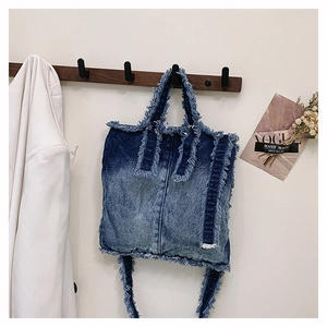 Vue détaillée du sac cabas en denim avec bords effilochés et dégradé de bleu