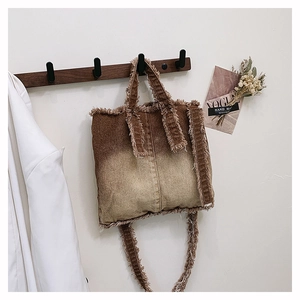 Détail d'un sac cabas en jean dégradé avec bords effilochés et doubles bandoulières