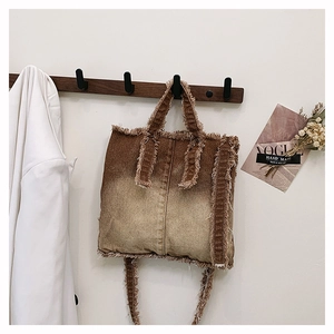 Détails du sac cabas en denim marron dégradé avec des bords effilochés de style vintage