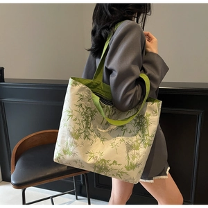 Detail of bamboo leaf print on a large canvas tote bag showing texture and vibrant green handles