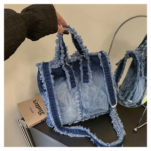 Détail du sac en jean montrant des bords effilochés et une texture délavée dégradée