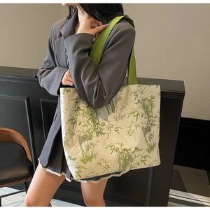 Detail view of large canvas tote bag featuring green bamboo leaf print and woven strap