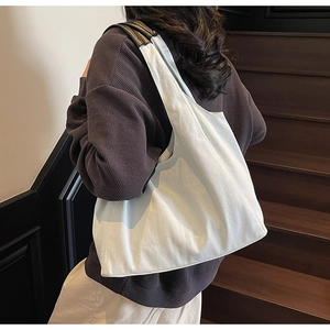 Vista dettagliata della borsa tote grande in denim crema indossata da una modella