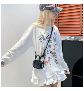 Streetstyle-opname van een oversized wit T-shirt met kleurrijke cartoonhonden en accessoires