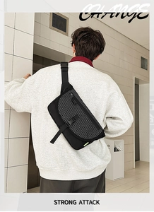 Dettaglio borsa a tracolla con texture a scacchi bianco e nero e chiusura con fibbia
