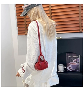 Rode lederen mini bowlingtas gedragen als crossbodytas in een straatstijl setting